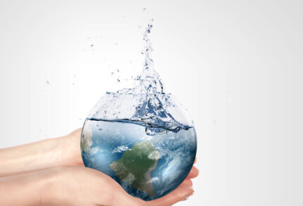 Globe in human hand against blue sky. Environmental protection concept. Elements of this image furnished by NASA